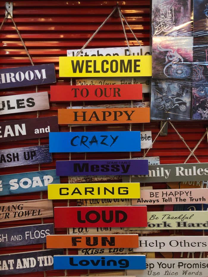 Vibrant wooden signs with messages like 'Welcome' and 'Happy' create a welcoming atmosphere.