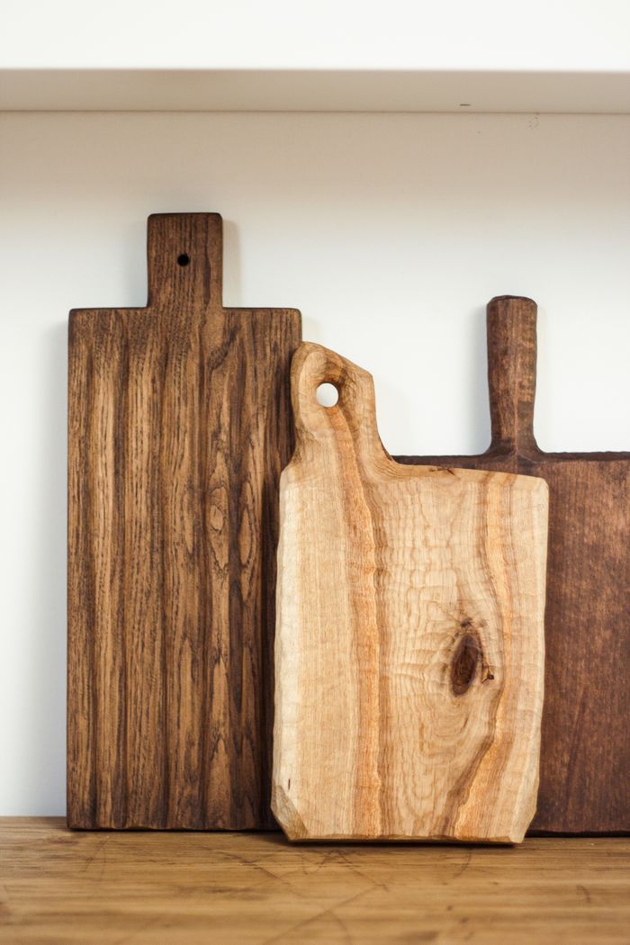 Collection of new wooden cutting boards arranged on table in light modern kitchen